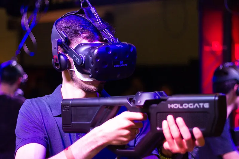 Guy with video game with gun and HTC Vive headset