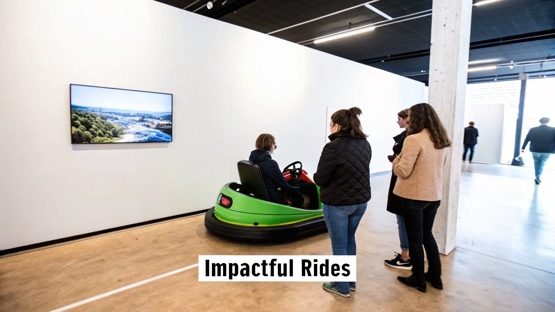 People in an art gallery, one seated in a green bumper car looking at a wall art.